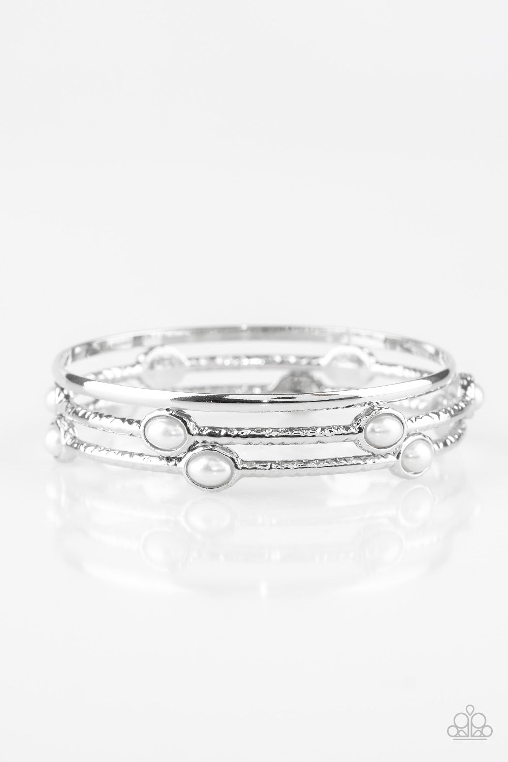 &lt;P&gt;Delicately hammered in shimmer, a pair of pearly white encrusted bangles joins a smooth silver bangle around the wrist for a refined fashion.  &lt;/P&gt;

&lt;P&gt;&lt;I&gt; Sold as one set of three bracelets.  &lt;/I&gt;&lt;/p&gt;


&lt;img src=\&quot;https://d9b54x484lq62.cloudfront.net/paparazzi/shopping/images/517_tag150x115_1.png\&quot; alt=\&quot;New Kit\&quot; align=\&quot;middle\&quot; height=\&quot;50\&quot; width=\&quot;50\&quot;/&gt;