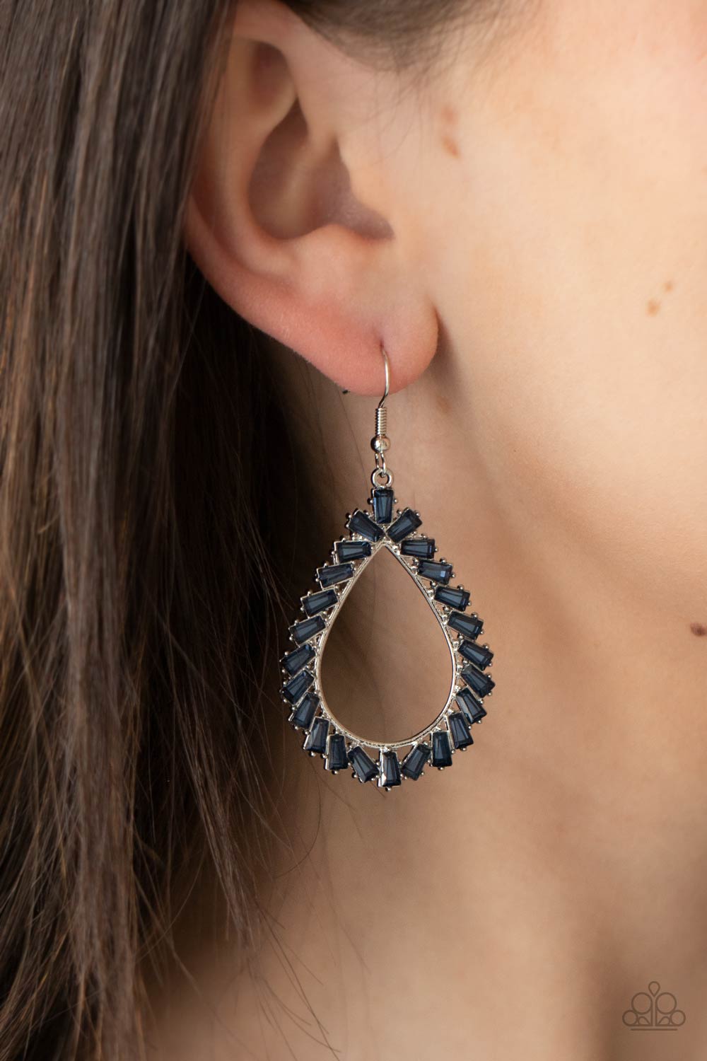&lt;p&gt;Featuring flared emerald style cuts, a glittery collection of blue gems adorn the front of a silver teardrop for a jaw-dropping dazzle. Earring attaches to a standard fishhook fitting.
  &lt;/p&gt;  
 

 &lt;p&gt; &lt;i&gt; Sold as one pair of earrings. &lt;/i&gt; &lt;/p&gt;
 

 

&lt;h5&gt;Paparazzi Accessories • $5 Jewelry&lt;/h5&gt;