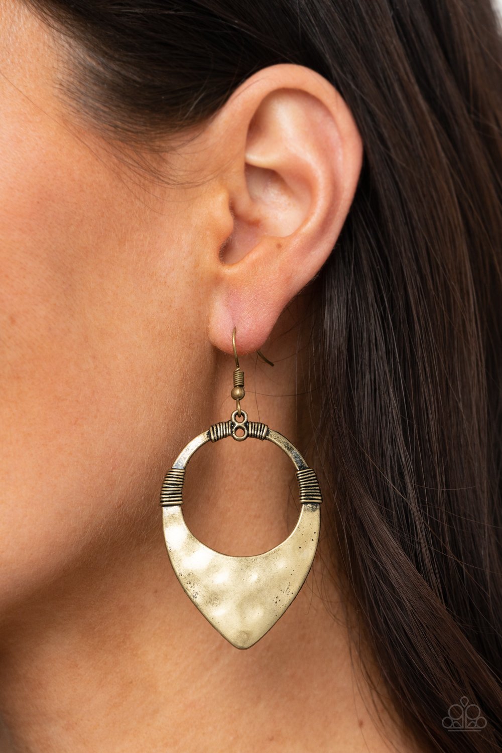 &lt;p&gt;Featuring faux wire wrap details, a hammered brass teardrop-like frame swings from the ear for an artisan inspired look. Earring attaches to a standard fishhook fitting. &lt;/p&gt;  

&lt;p&gt; &lt;i&gt;  Sold as one pair of earrings. &lt;/i&gt;  &lt;/p&gt;


&lt;img src=\&quot;https://d9b54x484lq62.cloudfront.net/paparazzi/shopping/images/517_tag150x115_1.png\&quot; alt=\&quot;New Kit\&quot; align=\&quot;middle\&quot; height=\&quot;50\&quot; width=\&quot;50\&quot;&gt;