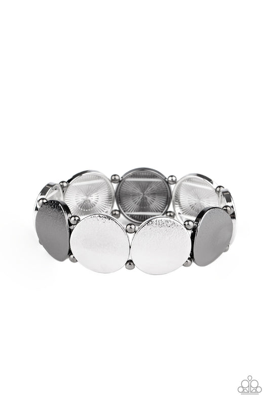 &lt;P&gt;Infused with pairs of dainty gunmetal beads, delicately hammered gunmetal and silver discs slide along a stretchy band around the wrist for a hint of industrial flavor.
&lt;/P&gt;  

&lt;P&gt; &lt;I&gt;Sold as one individual.&lt;/I&gt;  &lt;/P&gt;


&lt;img src=\&quot;https://d9b54x484lq62.cloudfront.net/paparazzi/shopping/images/517_tag150x115_1.png\&quot; alt=\&quot;New Kit\&quot; align=\&quot;middle\&quot; height=\&quot;50\&quot; width=\&quot;50\&quot;/&gt;