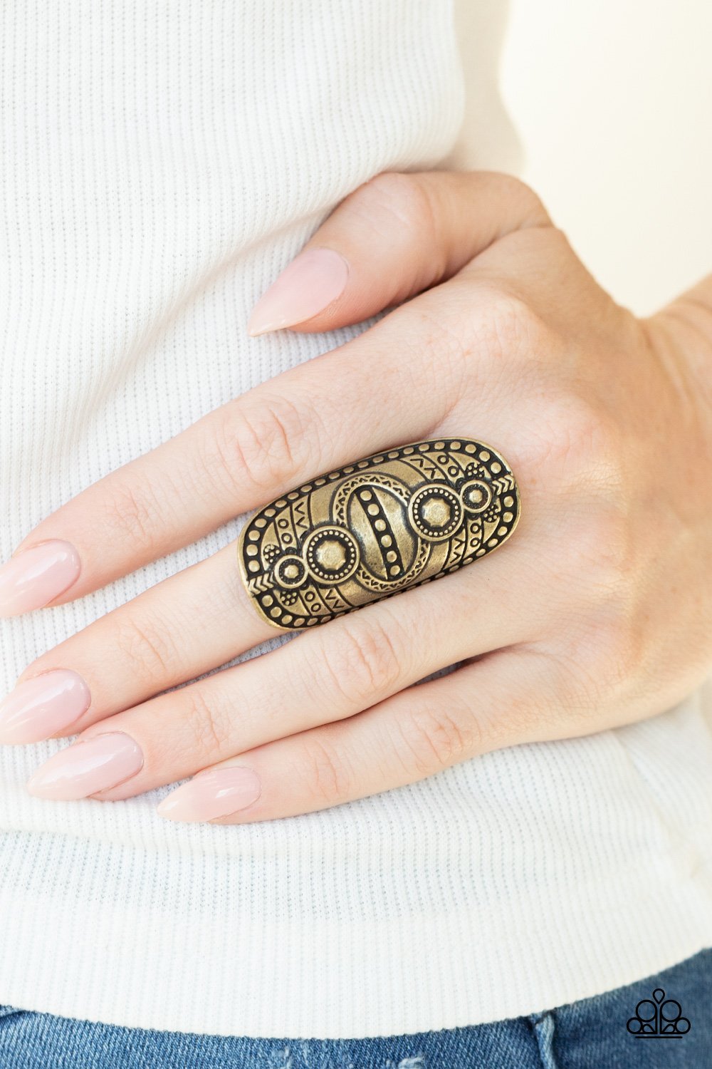 &lt;p&gt;Studded and stamped in tribal inspired textures, an oversized brass frame folds around the finger for a rustically authentic look. Features a stretchy band for a flexible fit. &lt;/p&gt;  
 

 &lt;p&gt; &lt;i&gt; Sold as one individual ring.
 &lt;/i&gt;&lt;/p&gt;
 

&lt;h5&gt;Paparazzi Accessories • $5 Jewelry&lt;/h5&gt;