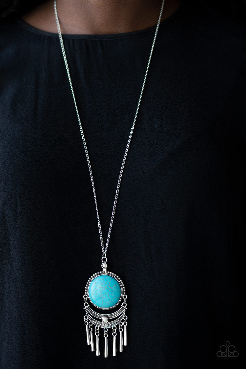 &lt;p&gt;Swinging from the bottom of a lengthened silver chain, a dramatic turquoise stone gives way to an ornate crescent shaped frame dotted with a dainty white stone. Brushed in an antiqued shimmer, flared silver bars swing from the bottom of the dramatic pendant, adding a playful movement to the seasonal palette. Features an adjustable clasp closure.&lt;/p&gt;

&lt;p&gt;&lt;i&gt; Sold as one individual necklace.  Includes one pair of matching earrings.
&lt;/i&gt;&lt;/p&gt;

