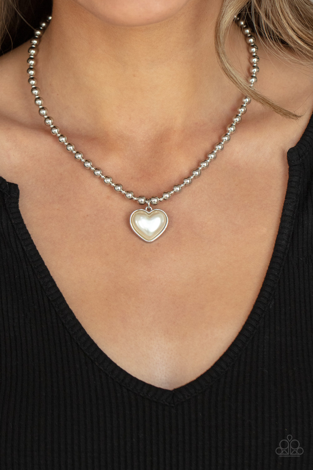 &lt;p&gt;Featuring a pearly white center, a charming heart pendant glides along a strand of silver beads below the collar for a romantic flair. Features an adjustable clasp closure. &lt;/p&gt;

&lt;p&gt;&lt;i&gt;  Sold as one individual necklace. Includes one pair of matching earrings.  &lt;/i&gt;&lt;/p&gt;

