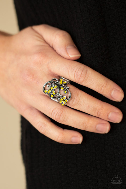 &lt;p&gt; Dotted with dainty yellow rhinestone centers, antiqued silver floral frames bloom across a studded backdrop for a sparkly seasonal look. Features a stretchy band for a flexible fit.&lt;/p&gt;  
 

 &lt;p&gt; &lt;i&gt; Sold as one individual ring.
 &lt;/i&gt;&lt;/p&gt;
 

&lt;h5&gt;Paparazzi Accessories • $5 Jewelry&lt;/h5&gt;