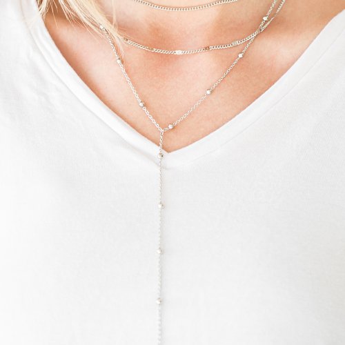 A row of beaded silver chain, a plain silver chain, and a chain featuring flattened links layer around the neck for a minimalist inspired look. Features an adjustable clasp closure. Sold as one individual choker necklace. Includes one pair of matching earrings.
